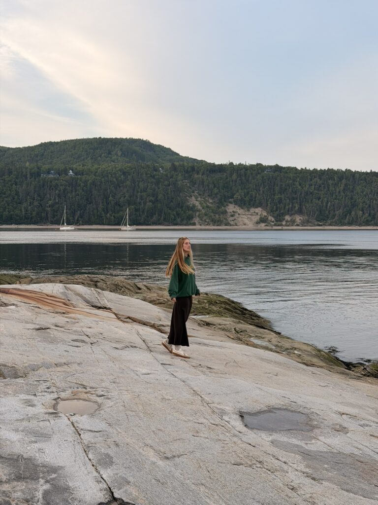 Canada Sentier côtier de la Pointe-de-l’Islet à Tadoussac voyageuse cheveux dans le vent au coucher de soleil